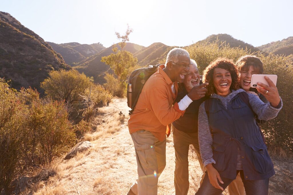 Group of happy retired people taking a selfie while on a hike