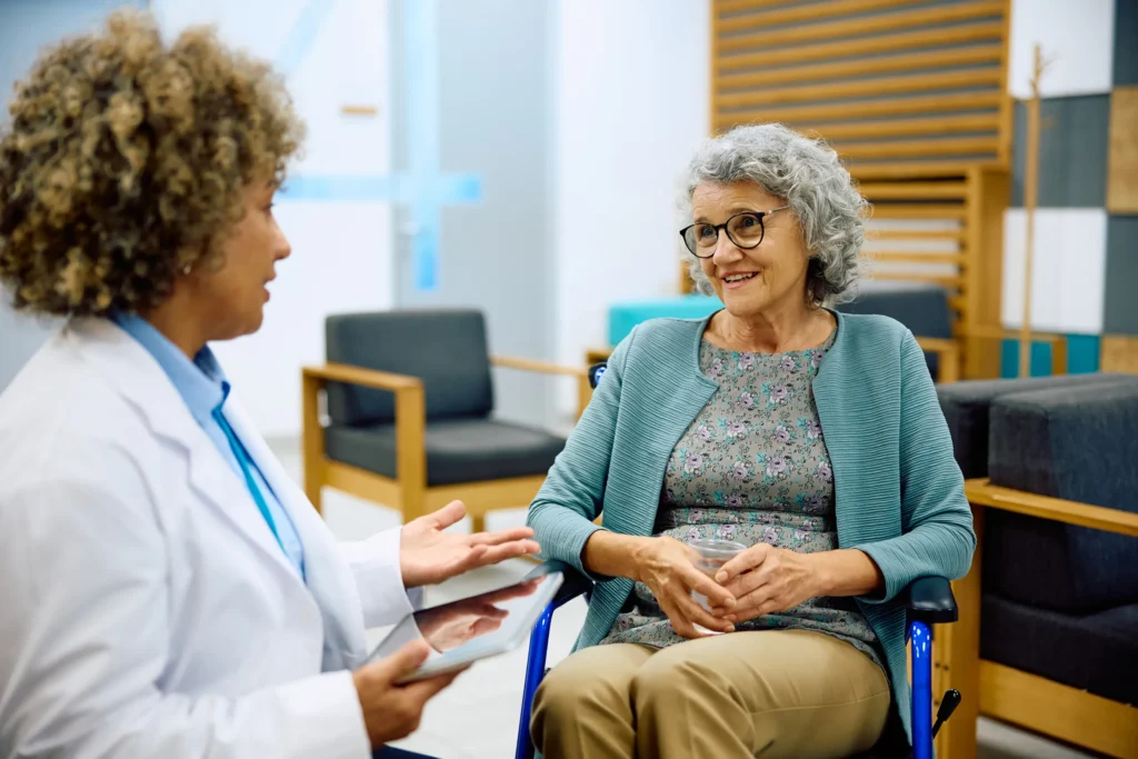elderly woman talking to nurse in waiting room