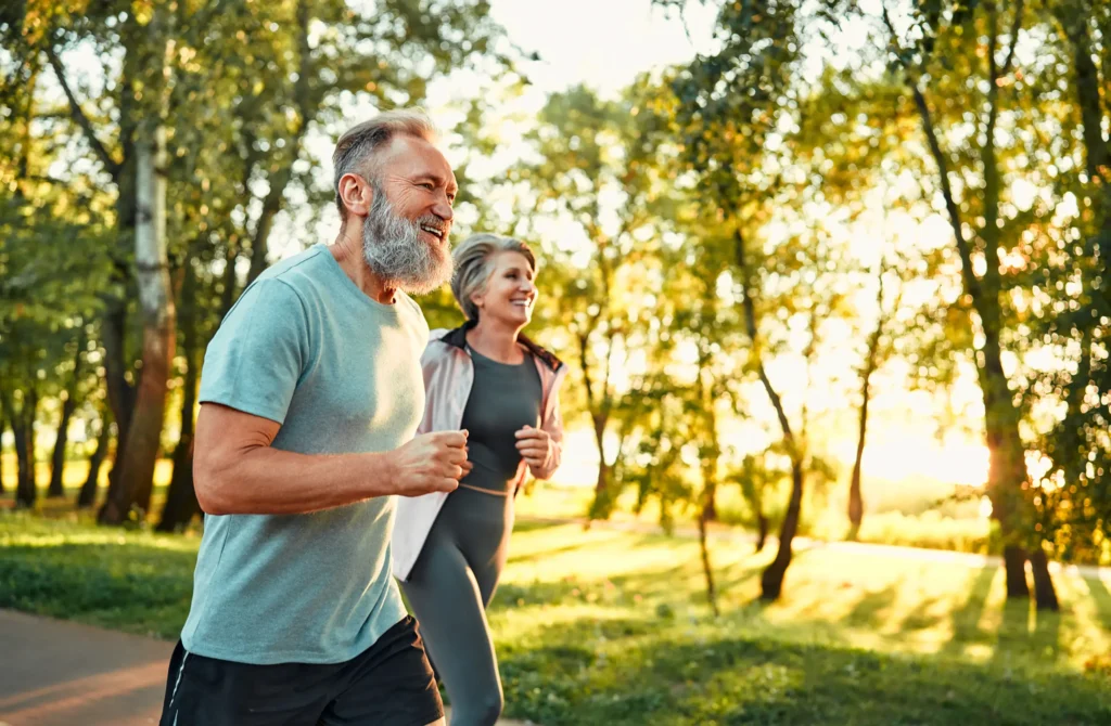 older couple jogging outside in park