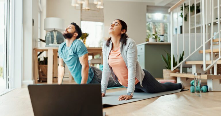 two people doing yoga at home